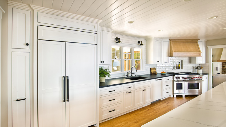 All white transitional kitchen design with panel ready appliances