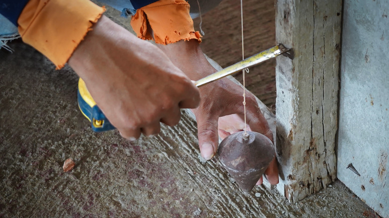 Checking wall with plumb bob