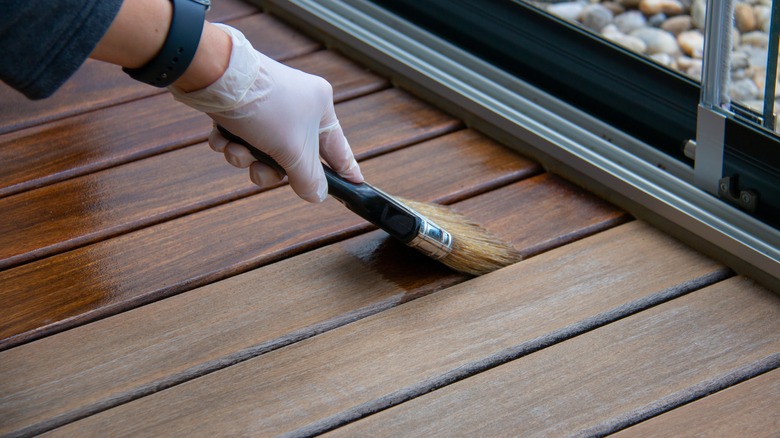 Person painting deck stain
