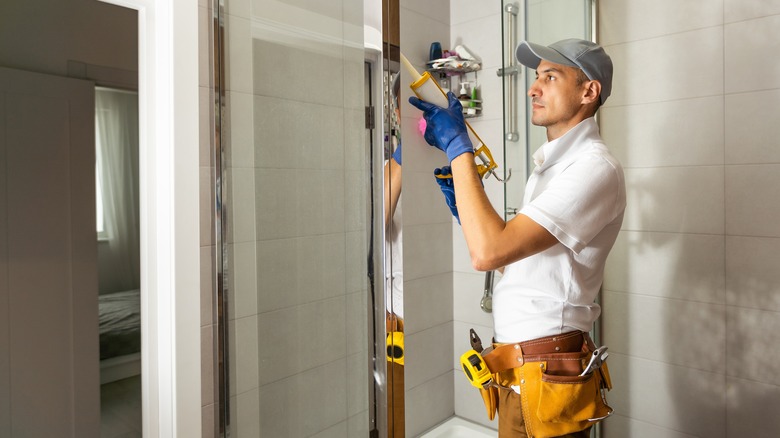 Worker caulking glass shower door
