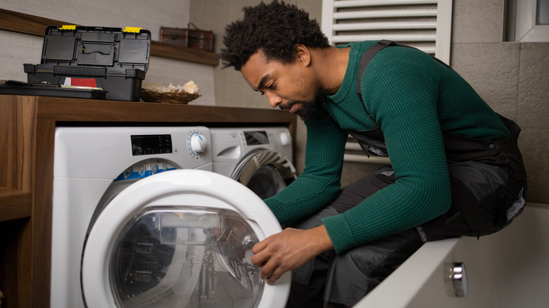 Appliance repairman fixing washing machine