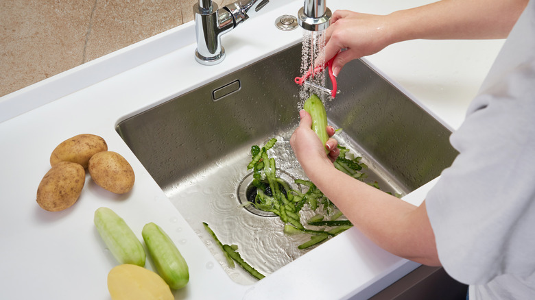 peeling vegetables in sink