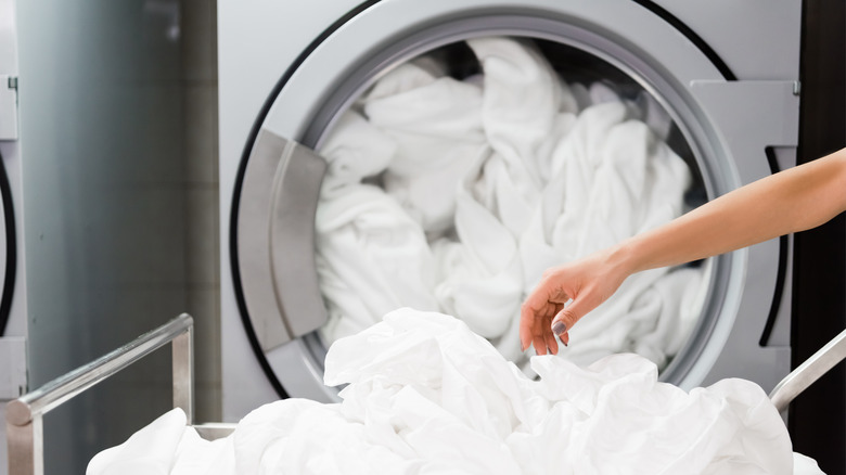 Person pulling sheets from dryer