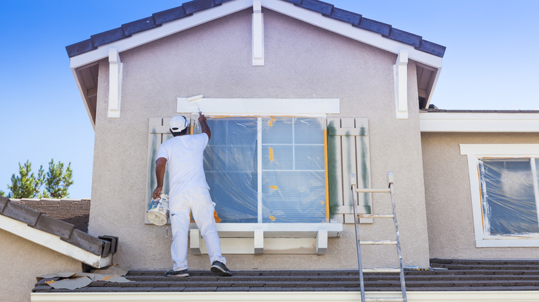 Painter works on home's roof