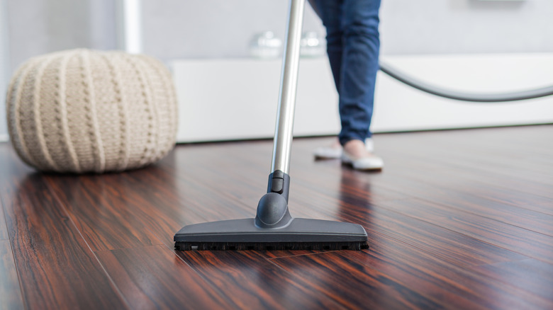 Woman vacuuming hardwood floors 