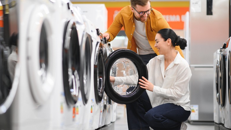 Couple looking at new washing machines at a store