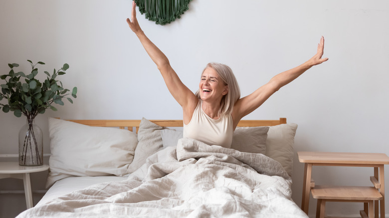 Woman stretching arms in bed