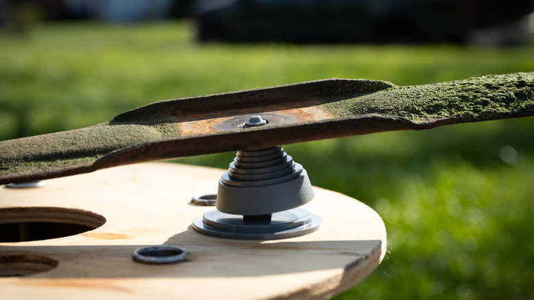 a Lawnmower blade being checked for balance during sharpening process.