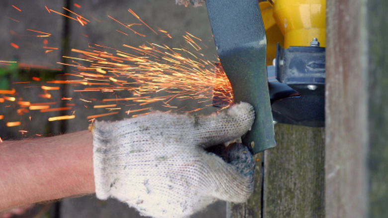 a person sharpening a mower blade