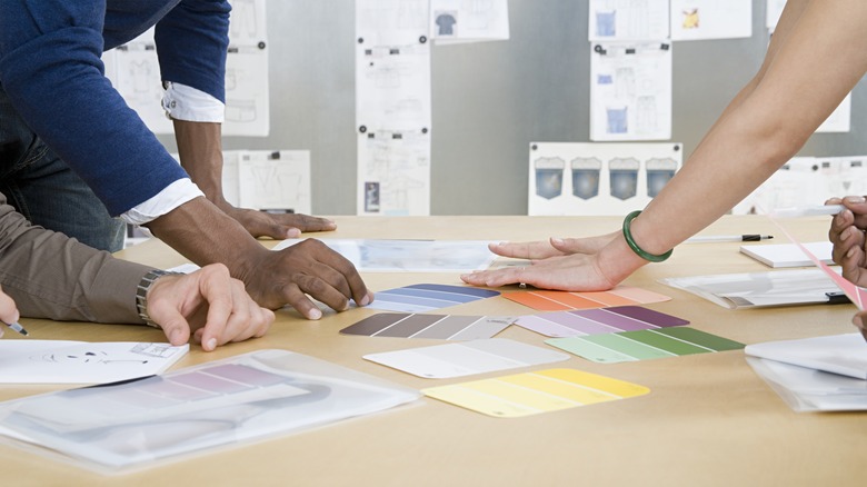 Hands touching color samples on table