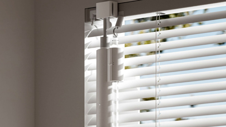 The SwitchBot Blind Tilt installed on a set of plastic slat blinds.