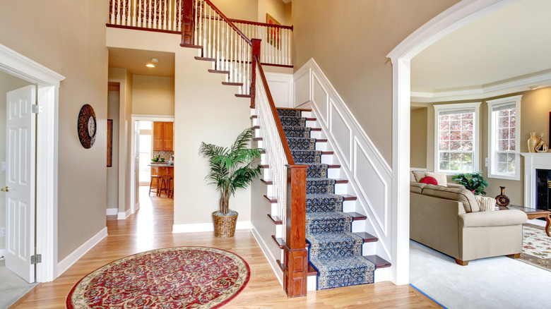 A wooden staircase in a traditional home with blue runner