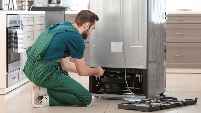 repairman fixing fridge