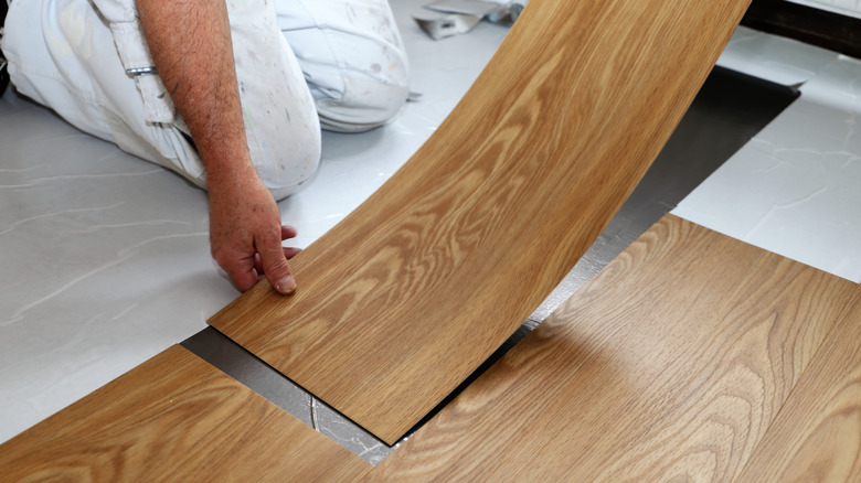 Man laying PVC floor tile