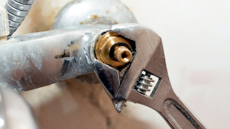 Person using a wrench on a shower valve