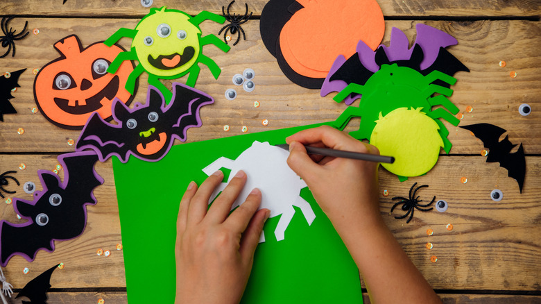 A hand drawing around a Halloween stencil