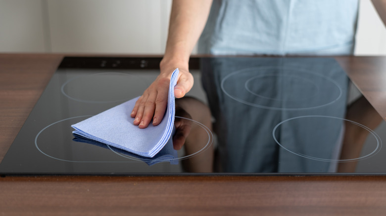 person wiping down stovetop