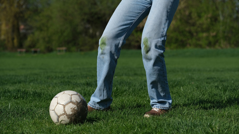 soccer player with visible grass stains on the knees