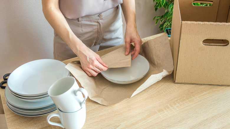 woman wrapping and packing plates