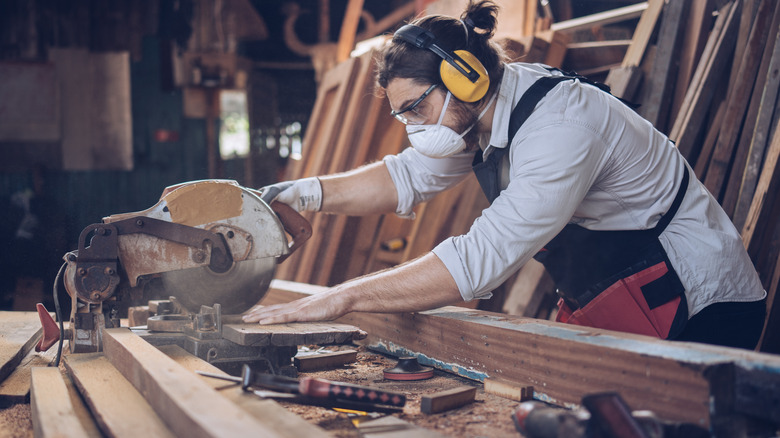 Man slicing wood with electric saw 