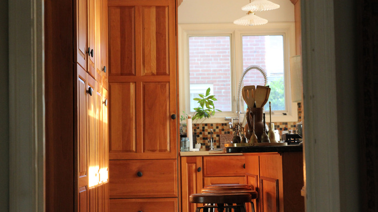 A kitchen with warm wood cabinetry and an island with seating.