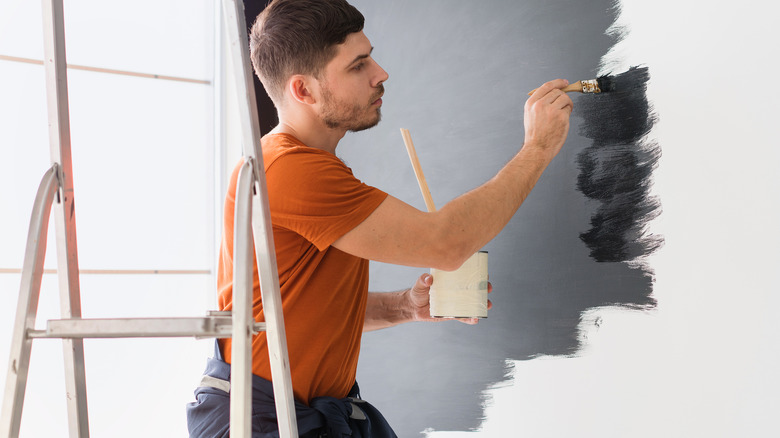 man painting wall black