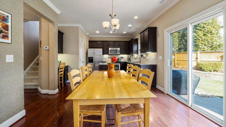 A large sliding glass door fills a dining room with light