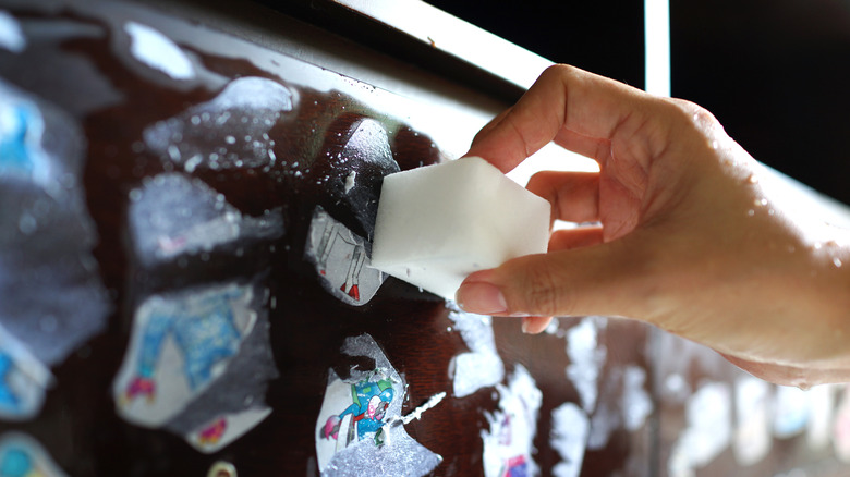 Woman cleaning stickers with sponge