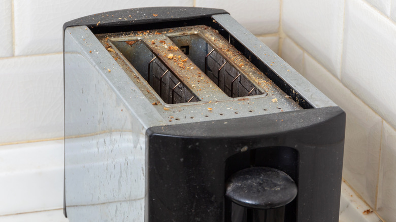 dirty toaster covered in crumbs