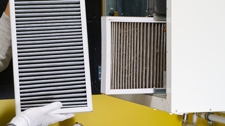 Person comparing a clean air filter to a dirty one.