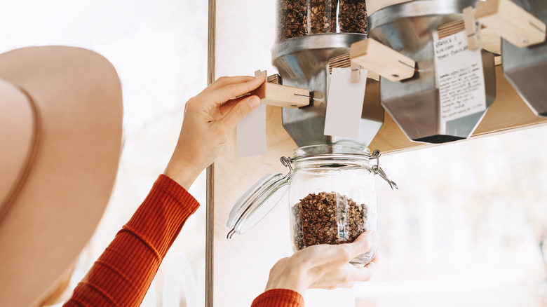 woman dispensing cereal into container