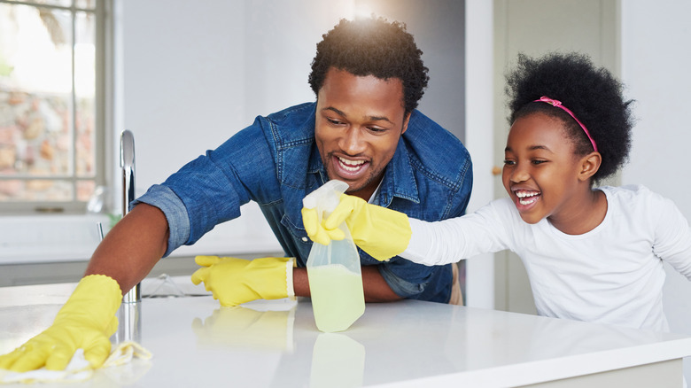 Dad and daughter clean counter