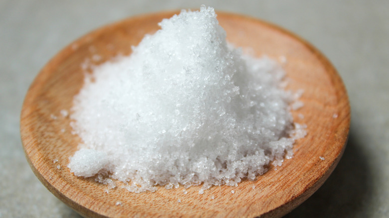 Small wooden bowl filled with a pile of white epsom salt.