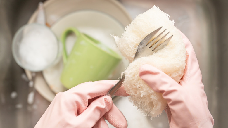 Person washing fork by hand