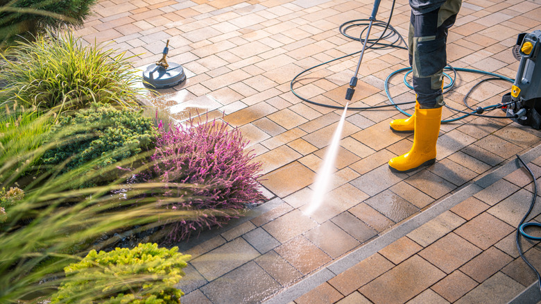 Someone power washing sealant-treated pavers