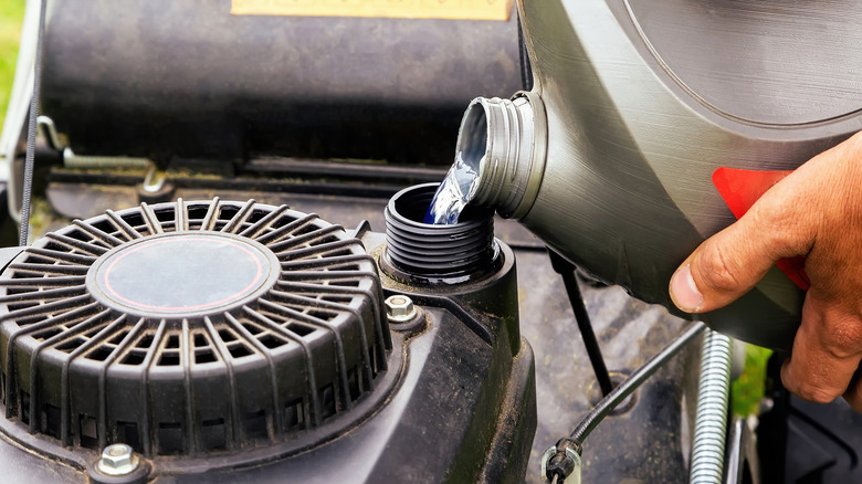 Pouring gasoline into mower tank