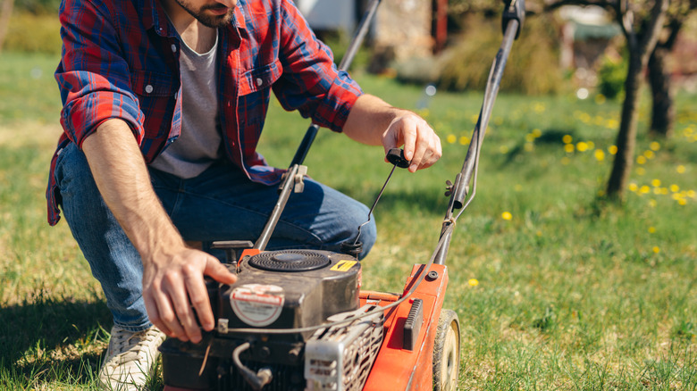 man checking lawn mower