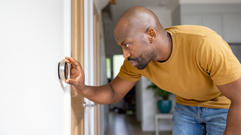 Man looking at thermostat