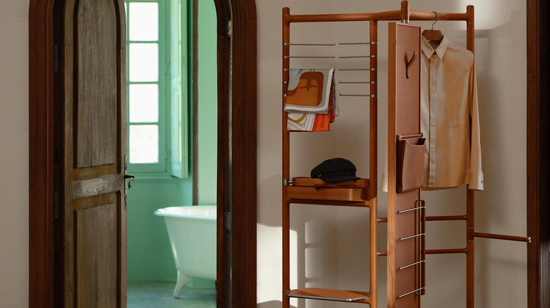 A luxury wooden clothing rack in a hallway.