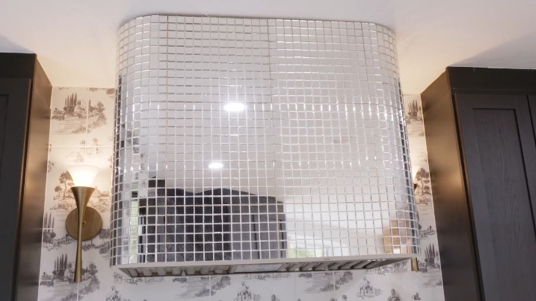 An oven hood covered in mirrored mosaic tiles