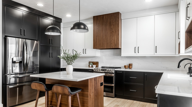Mismatching top and bottom cabinets in black and white with wood accents