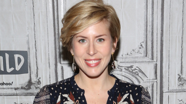 Photo of Erin Napier in front of a distressed white wall.