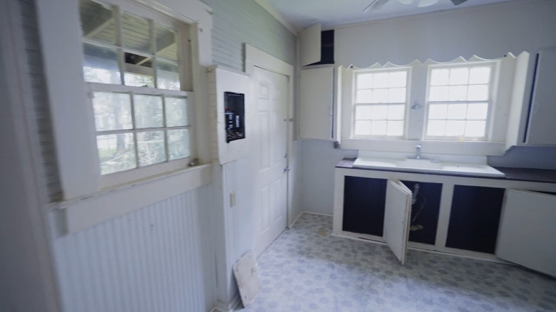 The corner of an old home with windows.