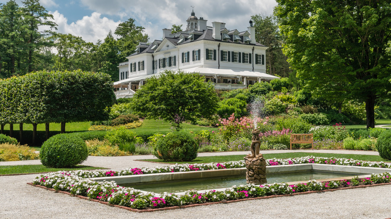 The gardens of The Mount, with a fountain, flowers, hedges, and the house in the background
