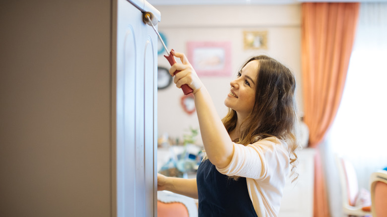 woman painting kitchen cabinets