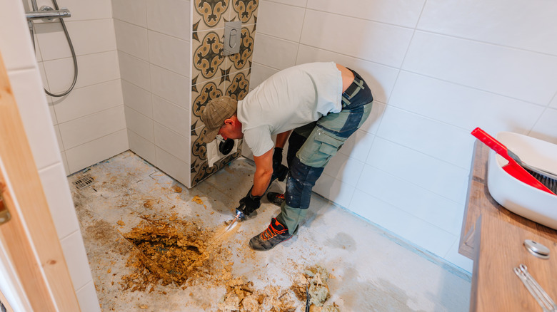 Contractor removing water damaged flooring in a bathroom