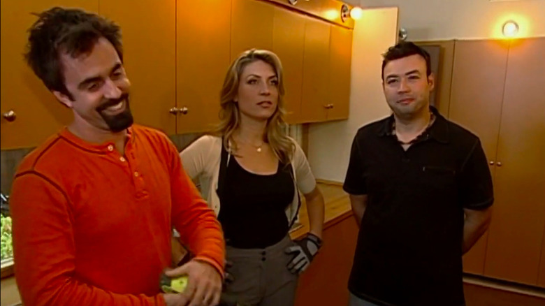Genevieve Gorder and two other people standing in a kitchen discussing a remodel.