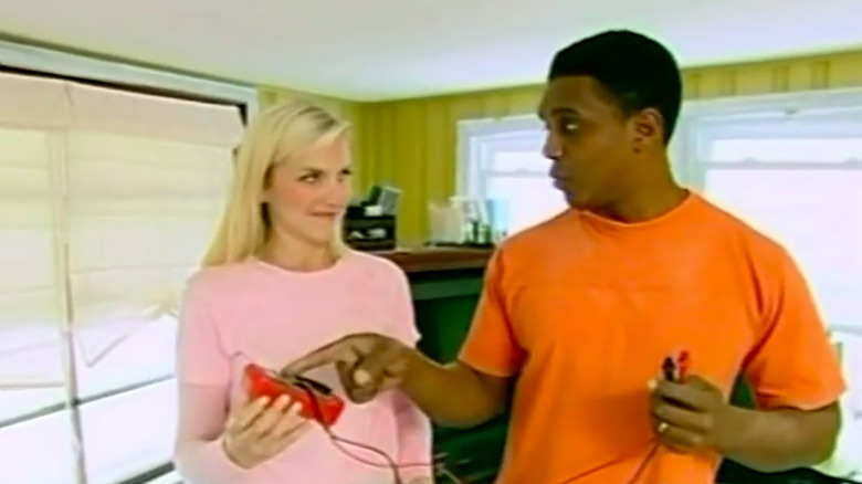 A man pointing at an object in a woman's hand.