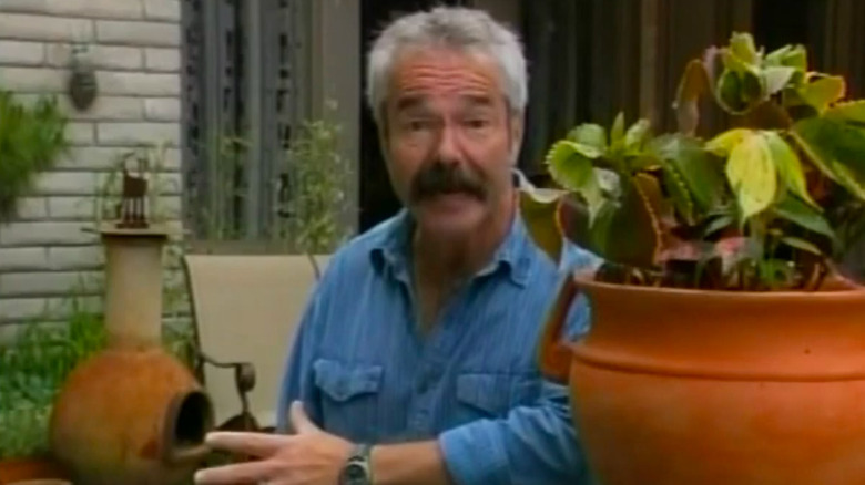 Paul James sitting outside with potted plants.