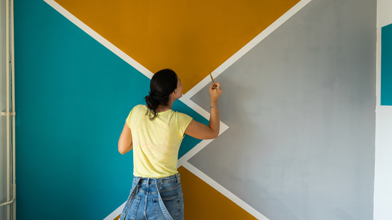 Woman painting design onto wall